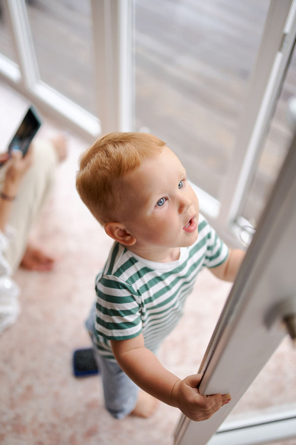 Toddler reaching for a door handle at home
