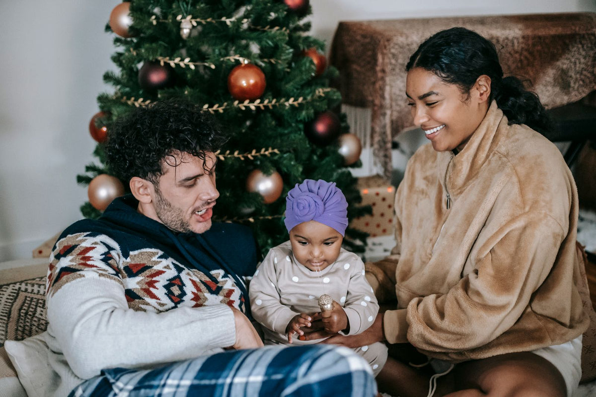 Parents with their baby in front of a Christmas tree